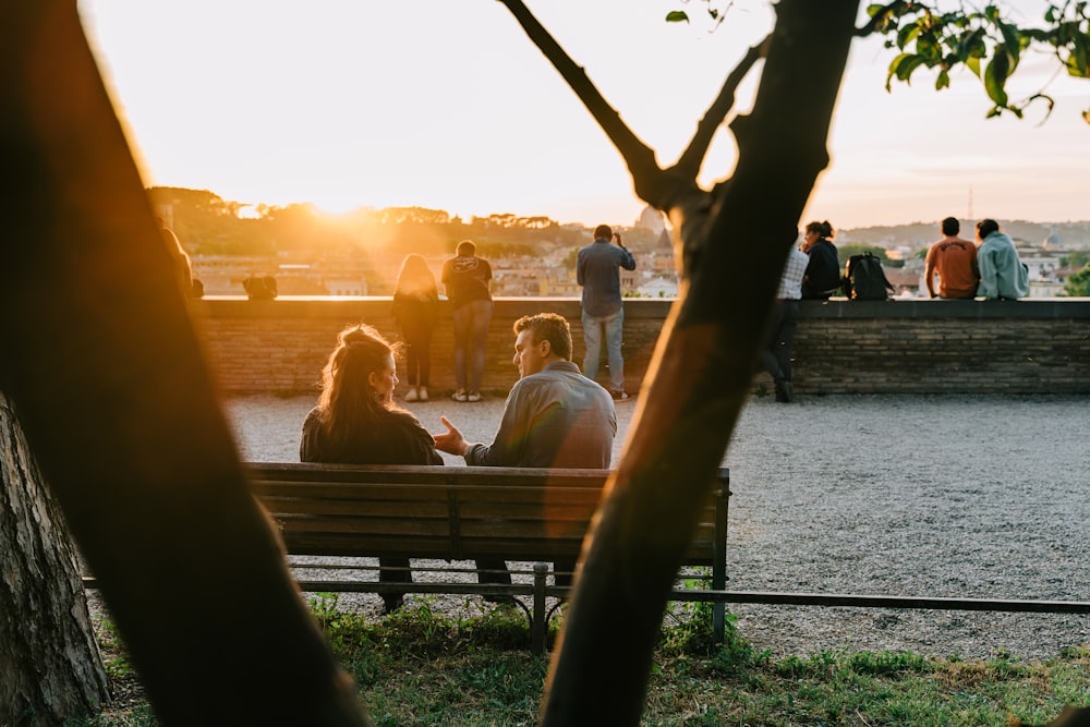 a group of people sitting on top of a wooden bench