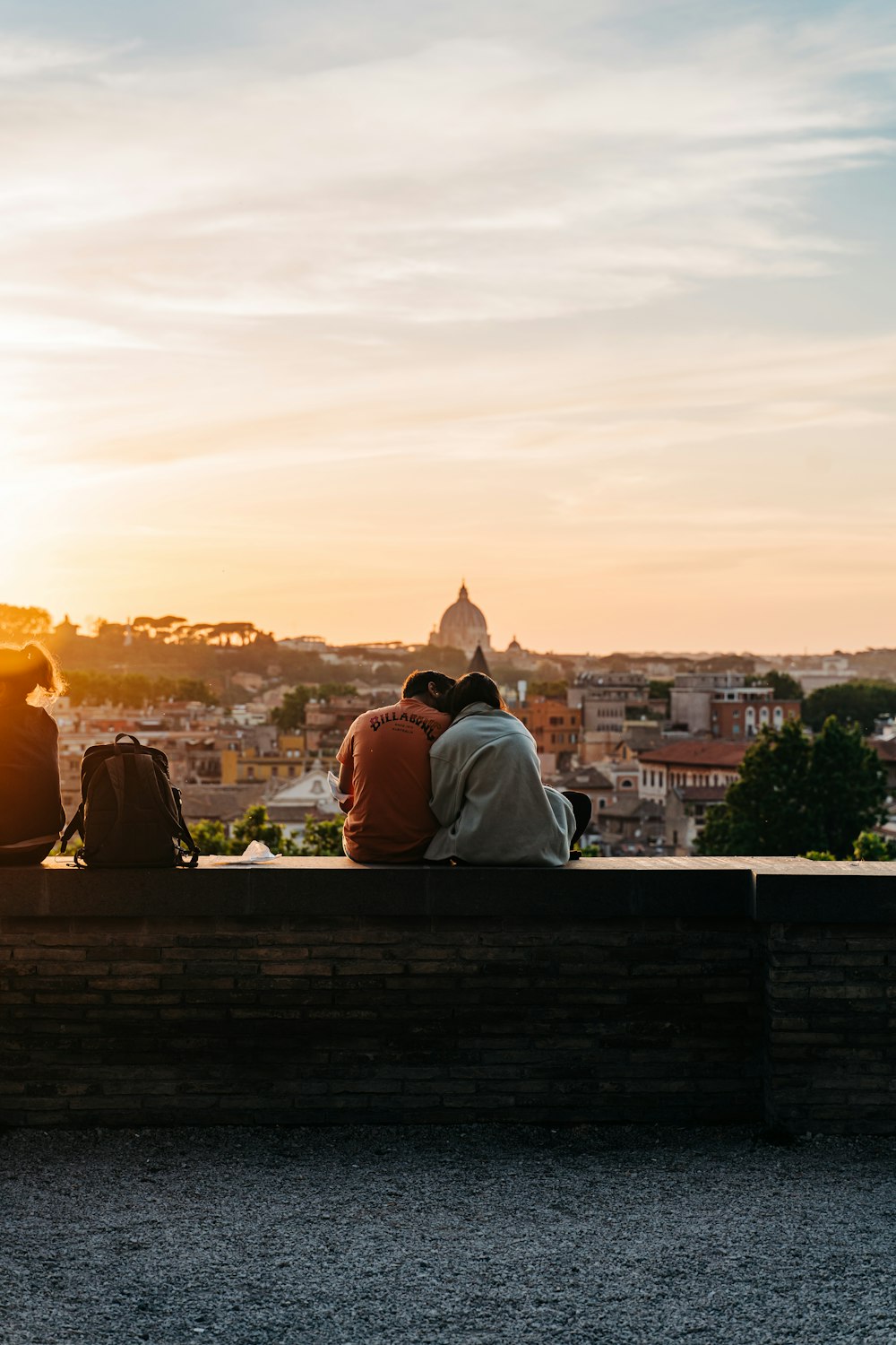 a couple of people sitting on top of a wooden bench