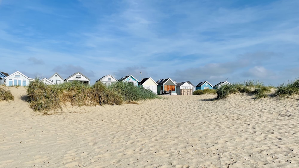 uma fileira de cabanas de praia sentadas no topo de uma praia de areia