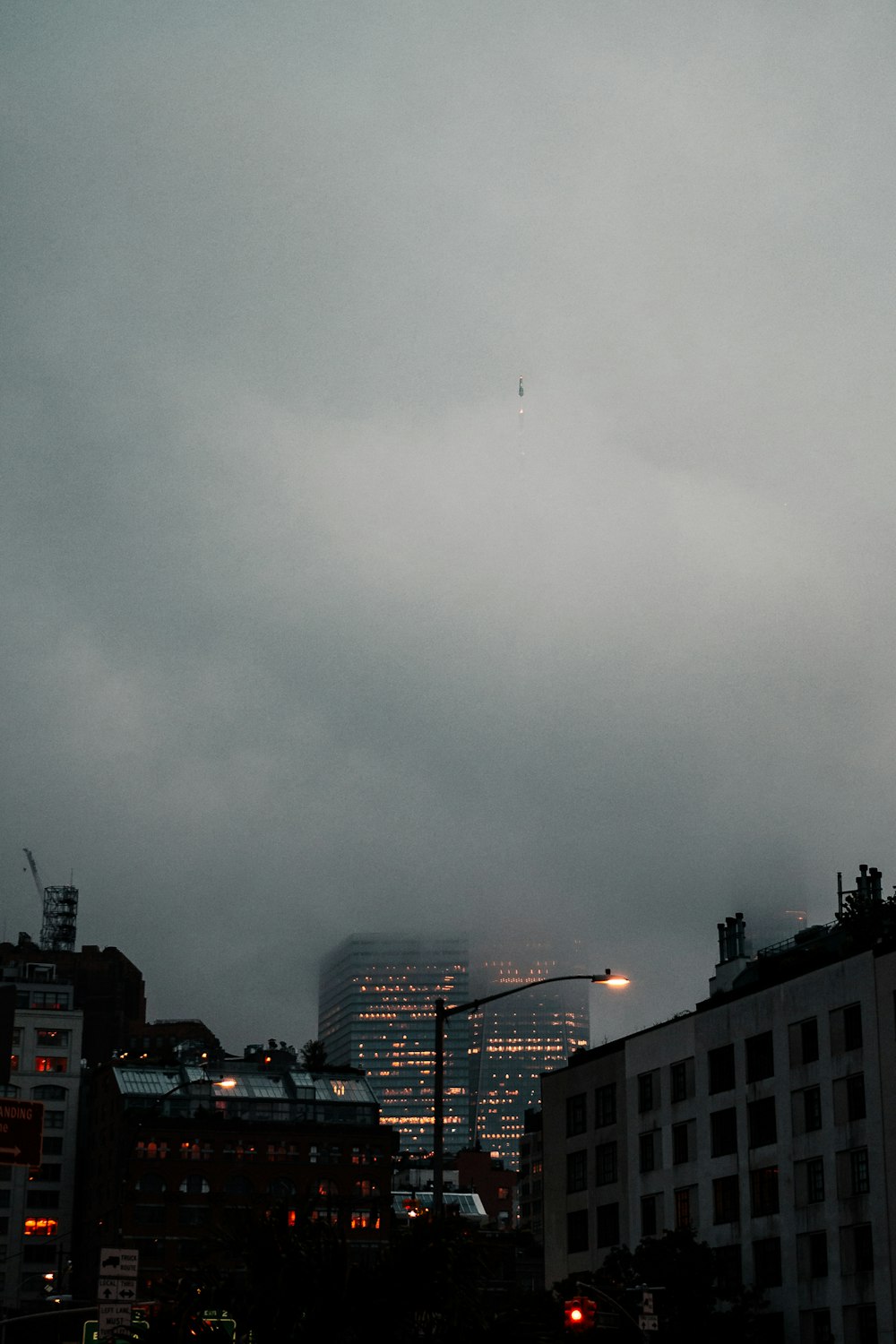 a city skyline at night with a plane flying in the sky