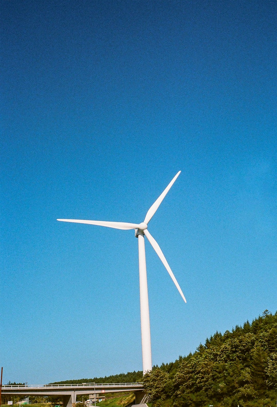 white wind turbine under blue sky during daytime