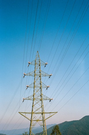 black electric post under blue sky during daytime
