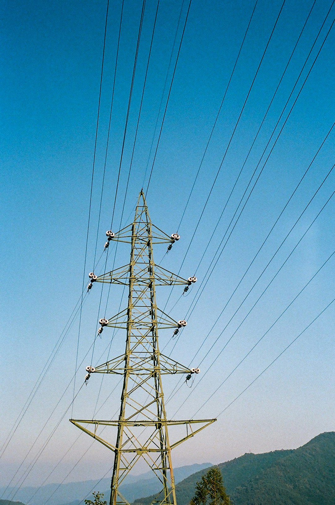 black electric post under blue sky during daytime