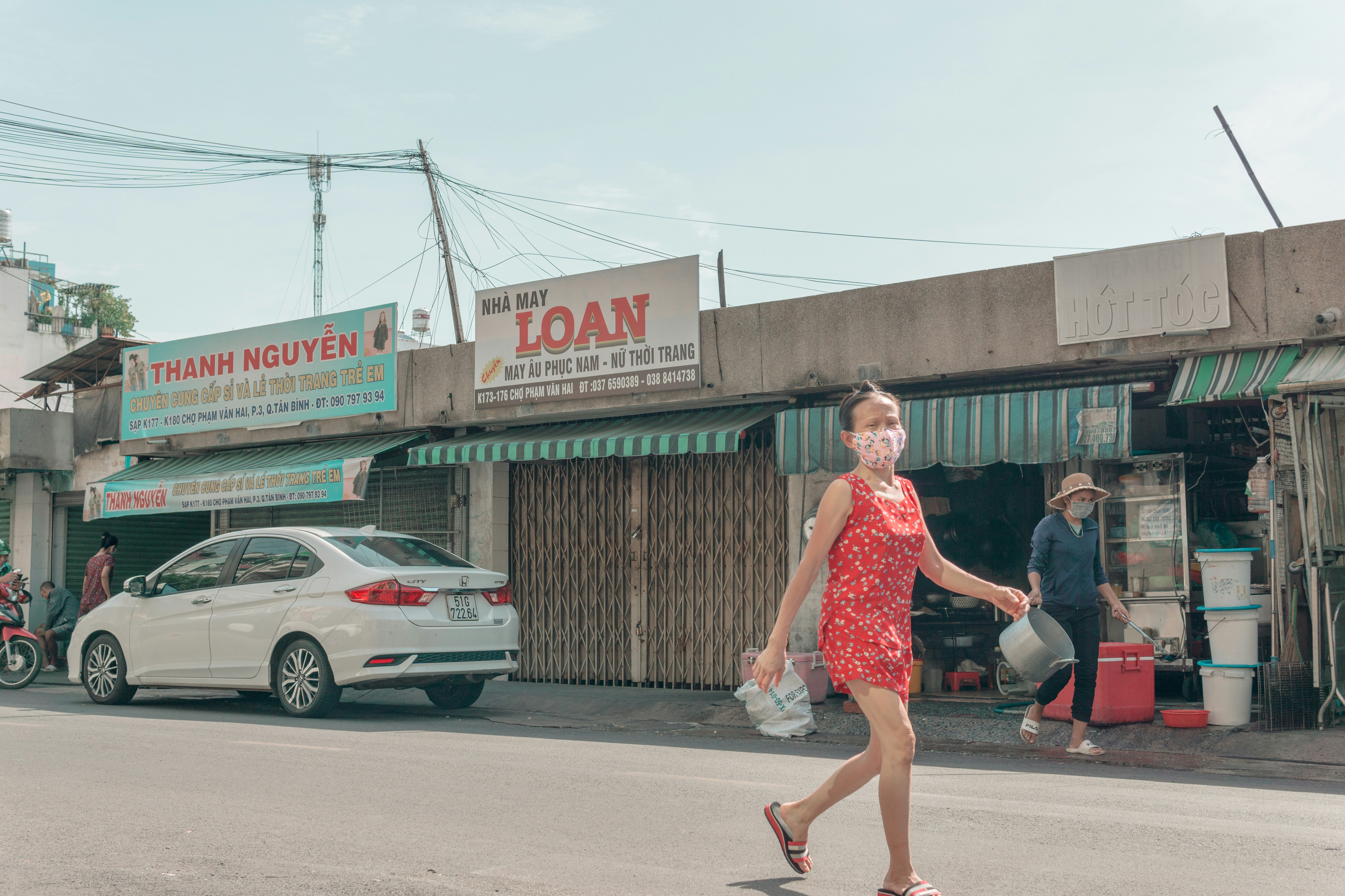 a woman in a red dress crossing a street