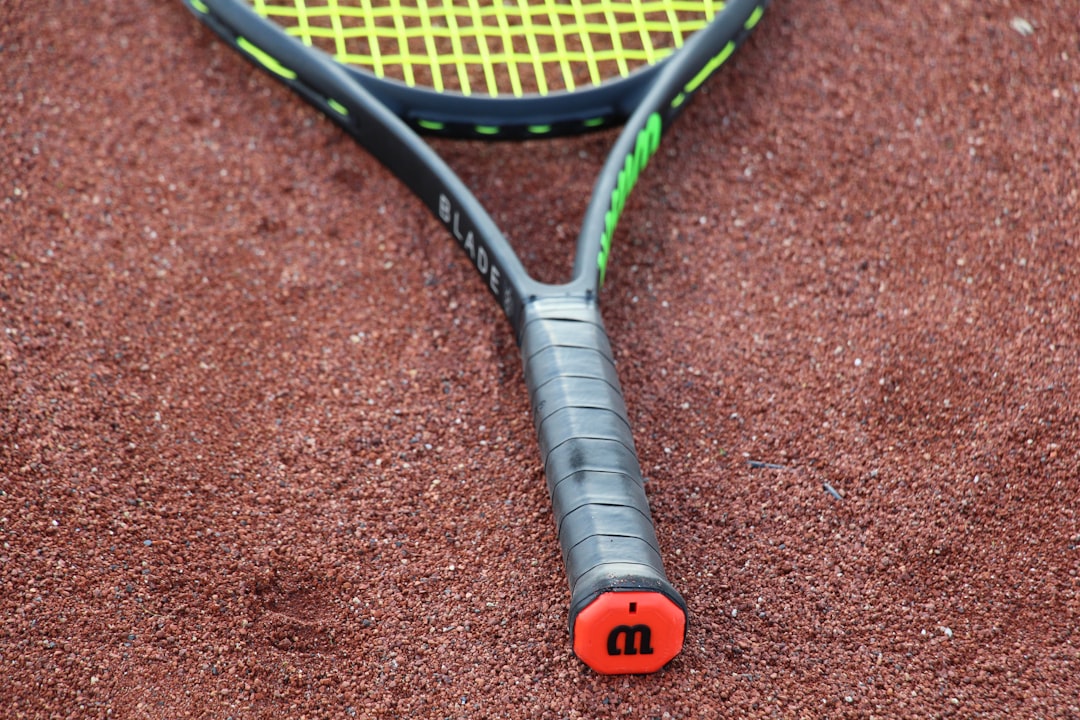 black and orange tennis racket