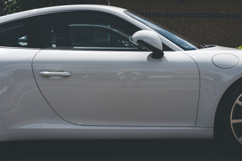 Voiture blanche garée sur le trottoir gris