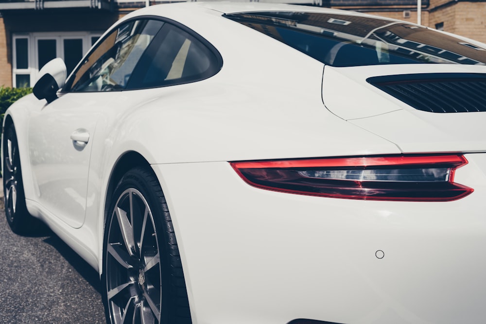 Porsche 911 blanche garée sur le parking