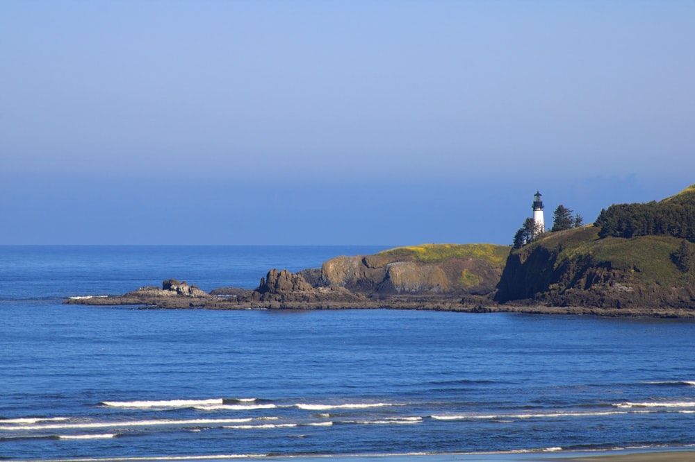 person standing on rock formation near sea during daytime