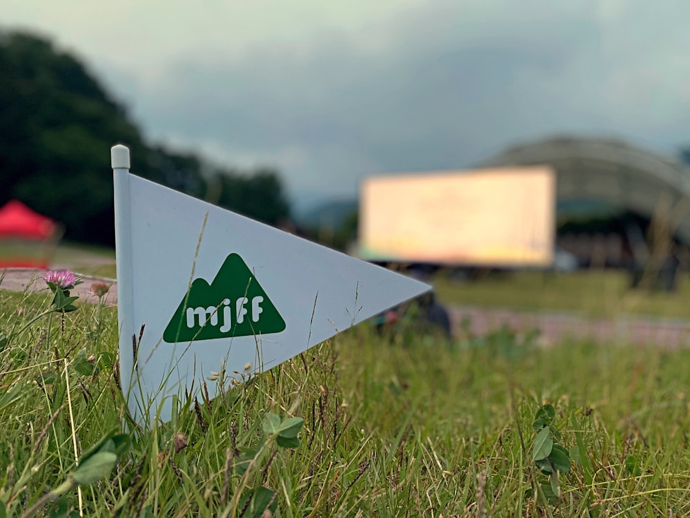 white and blue arrow sign on green grass field during daytime