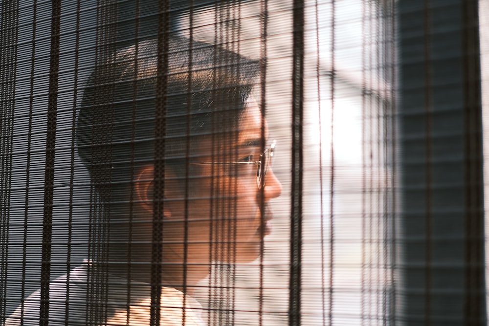 man in white shirt behind black metal fence