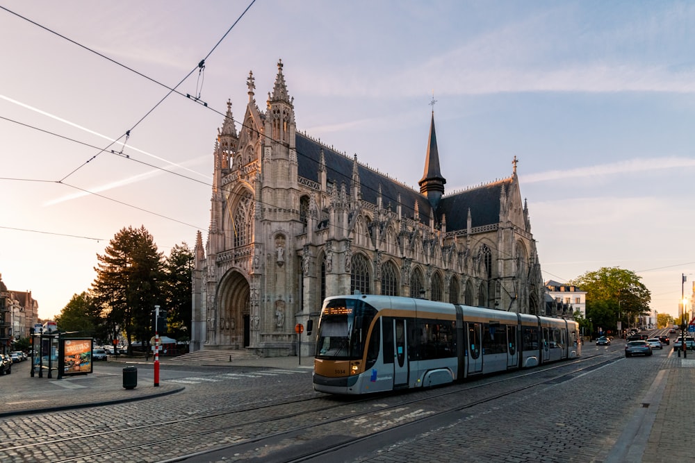 a train on a track in front of a large building