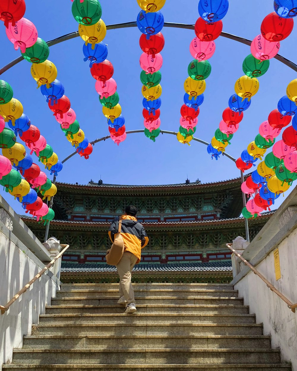 a man walking down a flight of stairs with a bunch of balloons