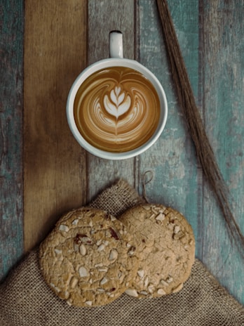 brown and white ceramic mug with cappuccino