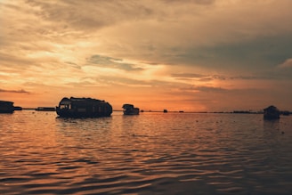 silhouette of boat on sea during sunset