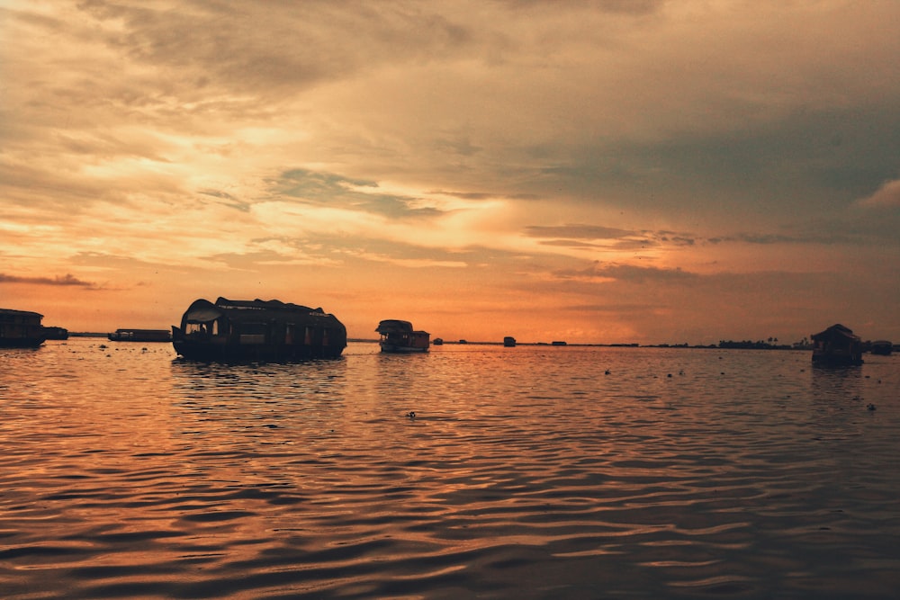 silhouette of boat on sea during sunset