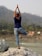 A person practicing yoga in a serene outdoor setting, surrounded by nature.