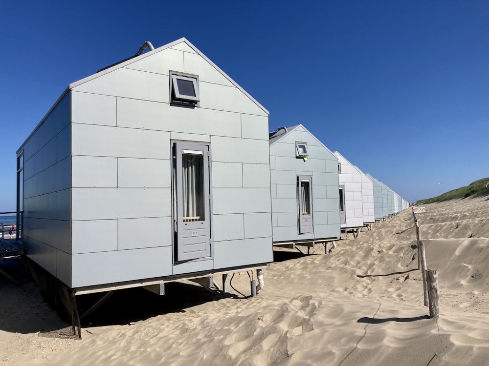 Casa de hormigón blanco sobre arena marrón bajo cielo azul durante el día