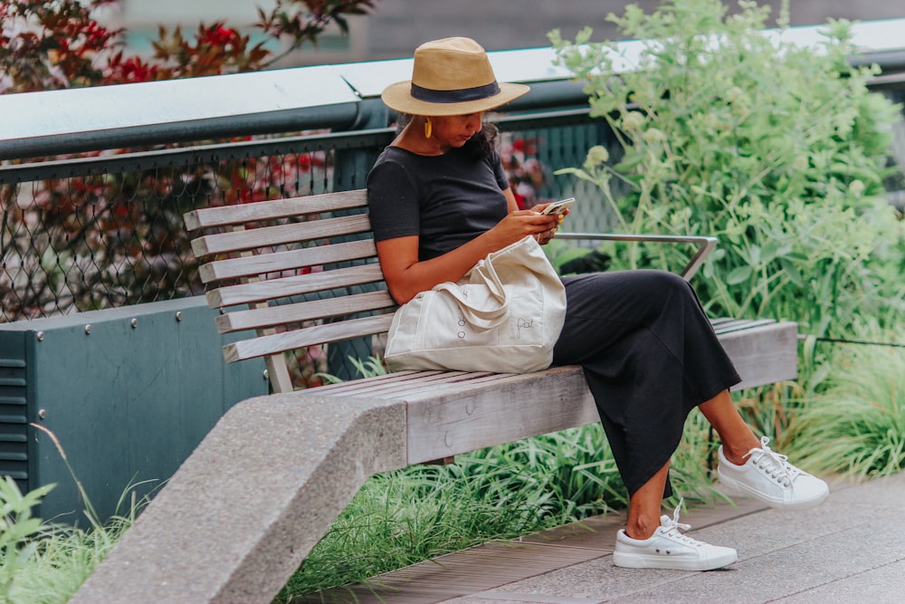 a woman sitting on a bench looking at her phone