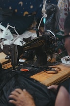 A cozy sewing workshop with colorful fabrics and a sewing machine on a wooden table.