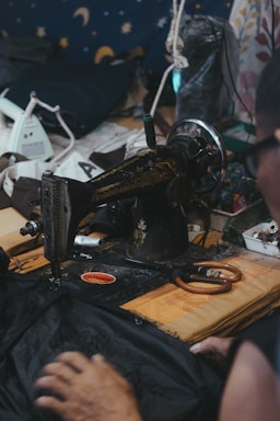 A cozy sewing workshop with colorful fabrics and a sewing machine on a wooden table.
