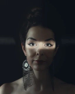Editorial-style portrait of a model wearing statement earrings, framed by soft shadows and clean lines.
