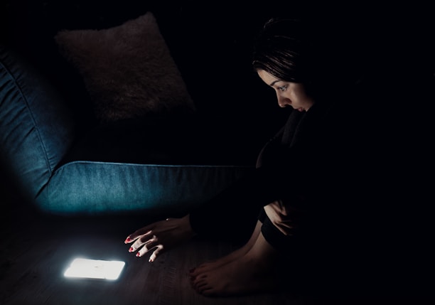 woman in black long sleeve shirt sitting on blue couch