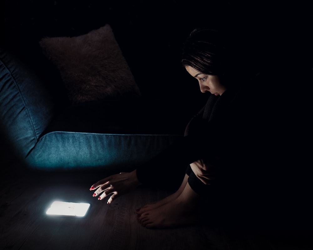 woman in black long sleeve shirt sitting on blue couch