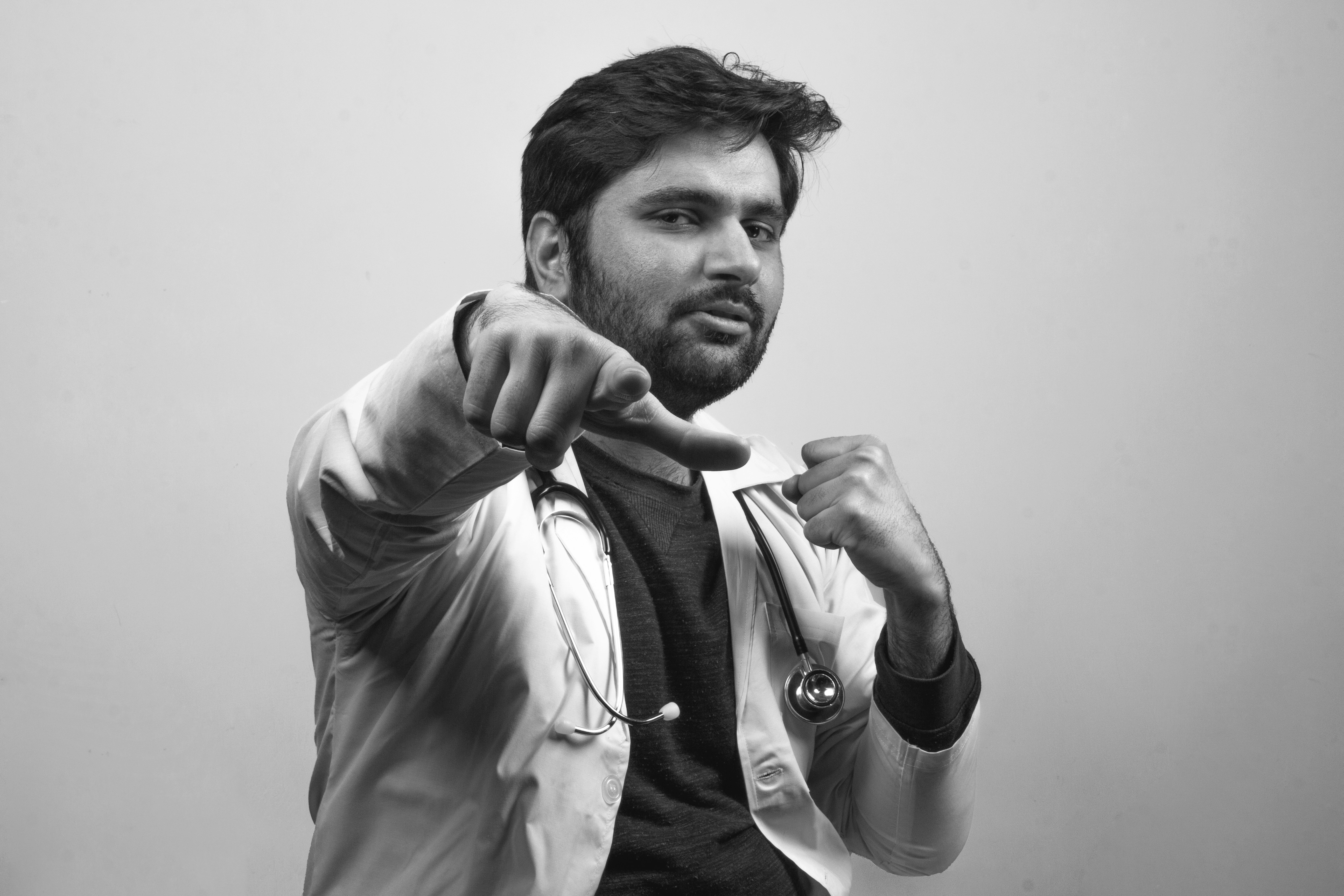 A doctor with joyful gesture pointing and punching forward - Black and White