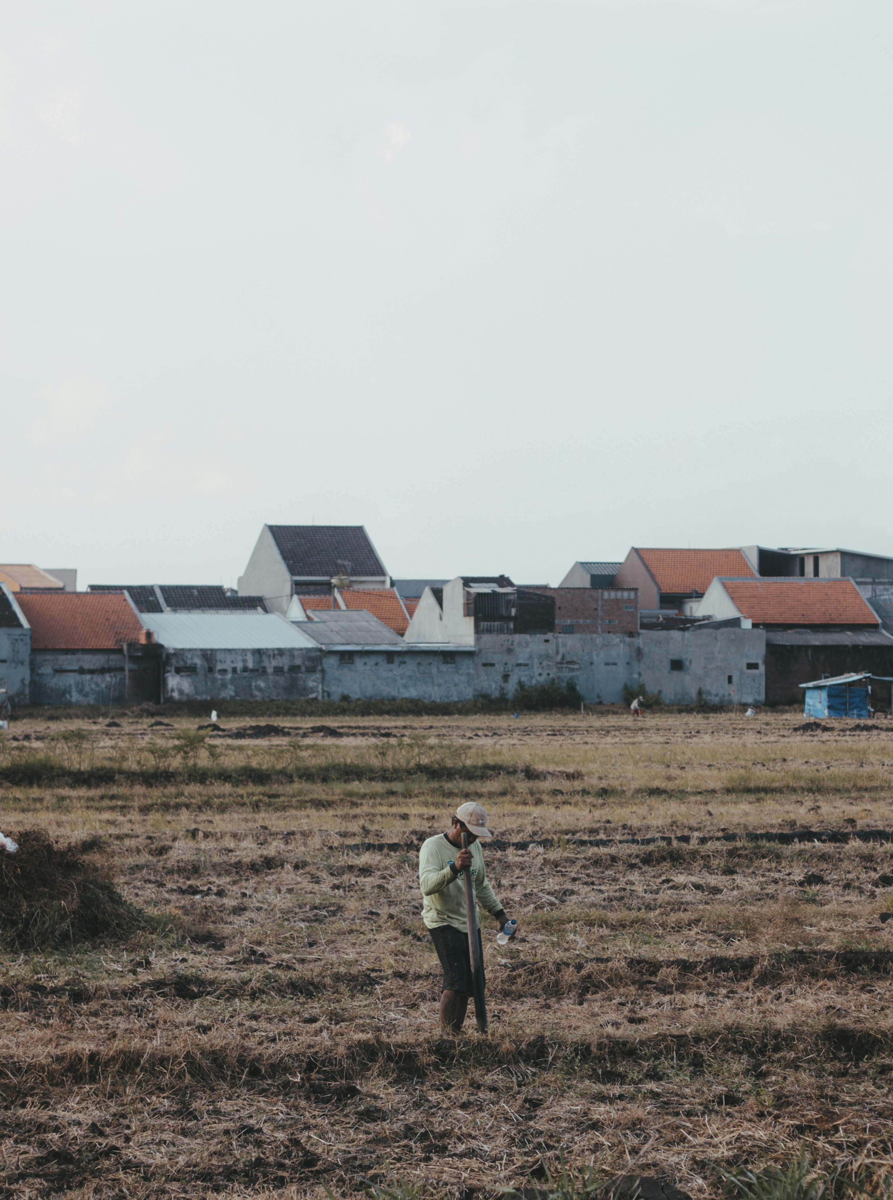 man in brown jacket walking on brown field during daytime