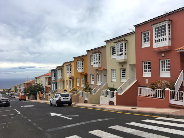 white car parked beside beige concrete building during daytime