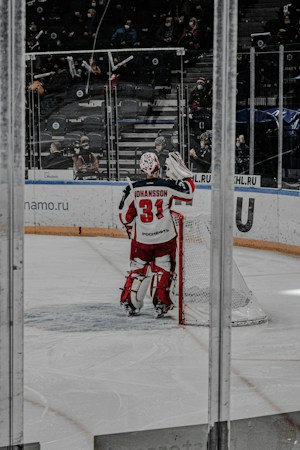 A hockey goaltender in full gear stands in front of the net inside an arena, the kind of scene fans saw as the Vegas Golden Knights opened Season X at T-Mobile Arena