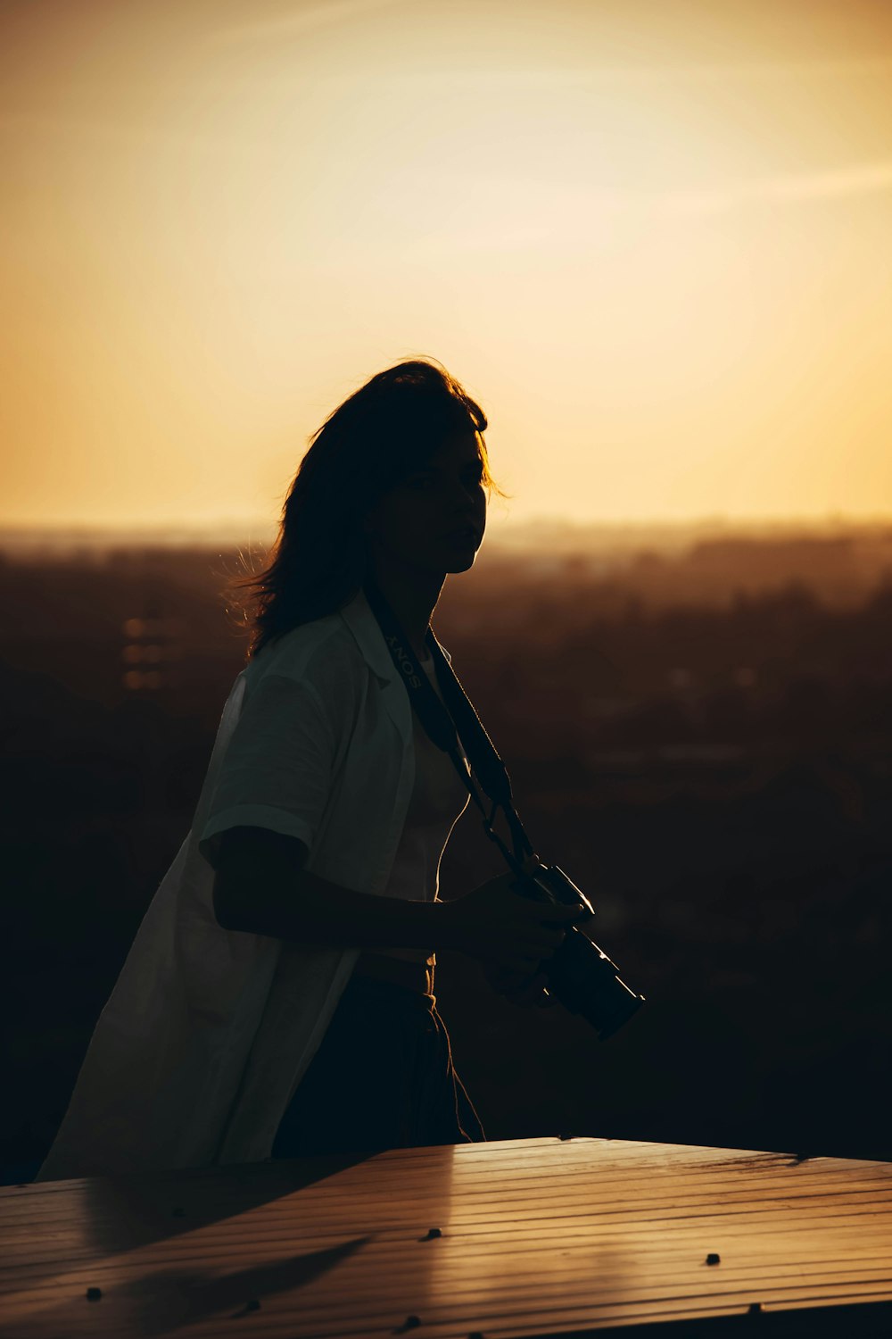 woman in white dress shirt standing on field during sunset