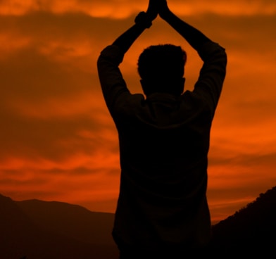 man in gray hoodie raising his hands