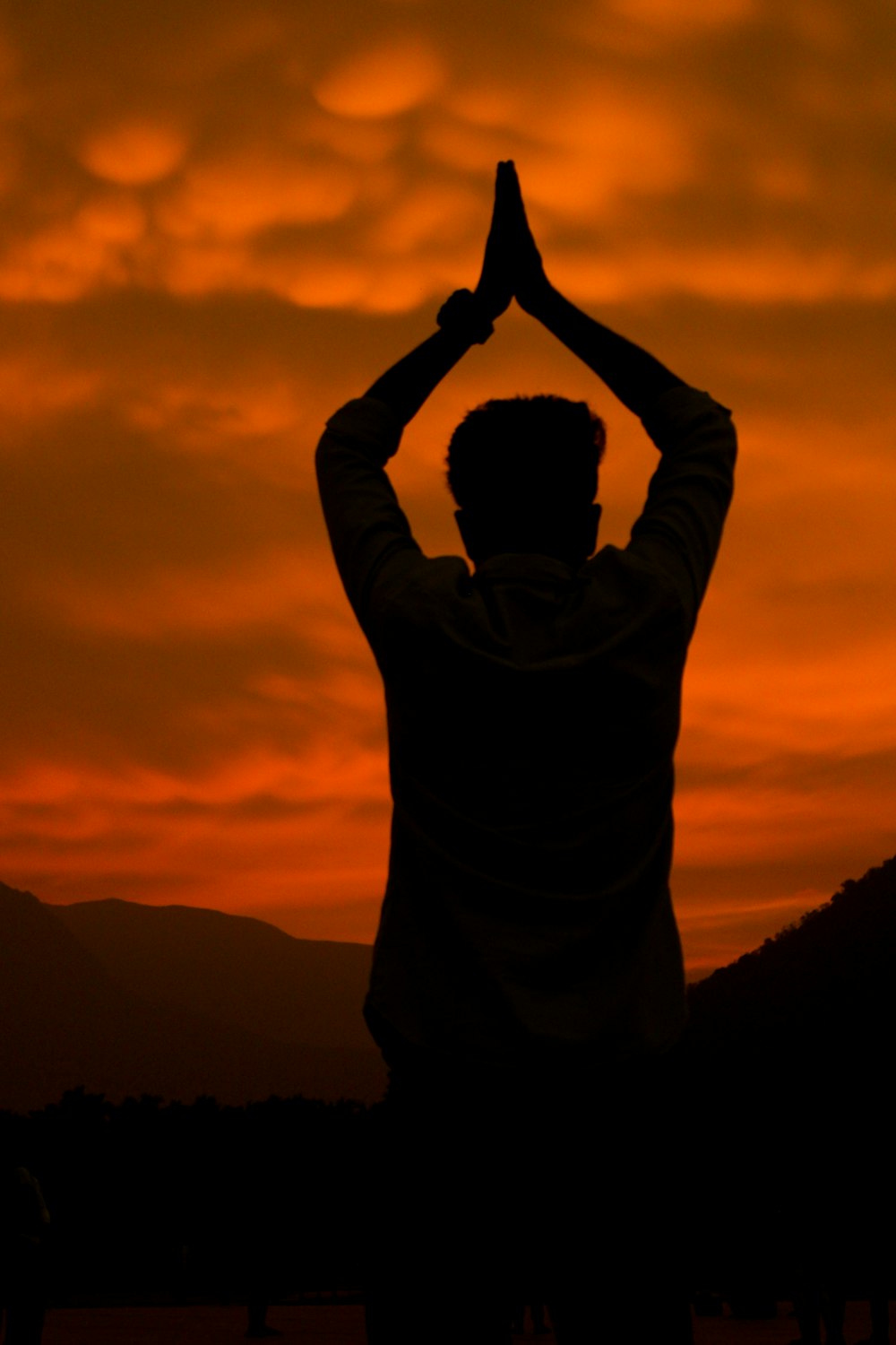 man in gray hoodie raising his hands