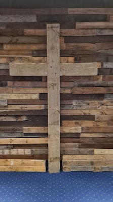 Driftwood brown textured wall with a delicate gold cross hanging.