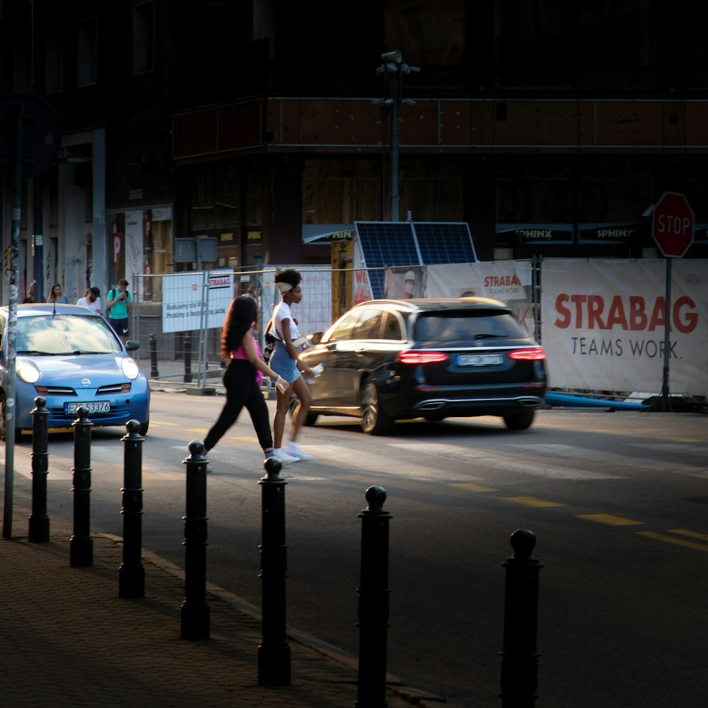 man in white t-shirt and blue denim jeans walking on sidewalk during daytime