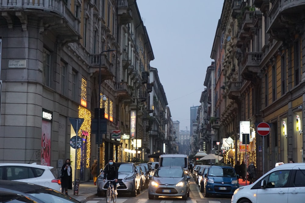 cars parked on street in between high rise buildings during daytime