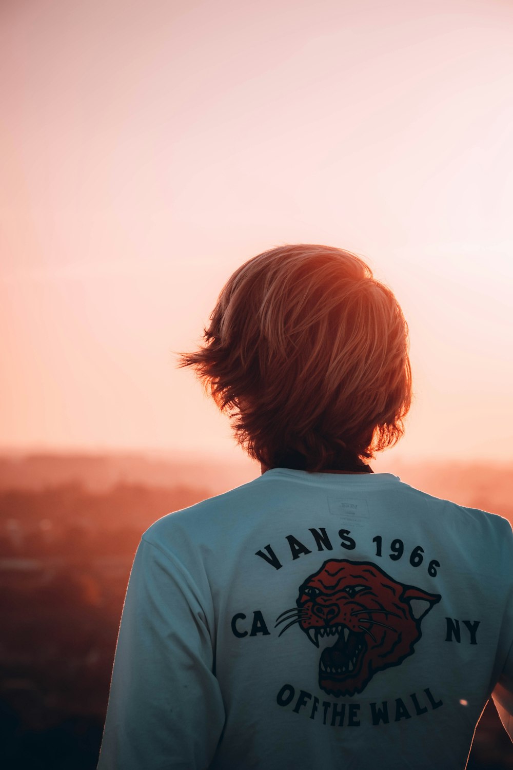 person in white crew neck shirt looking at the sky during daytime