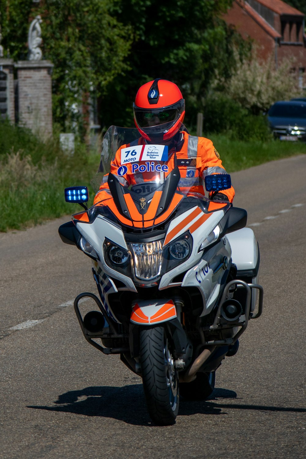 man in orange helmet riding sports bike on road during daytime