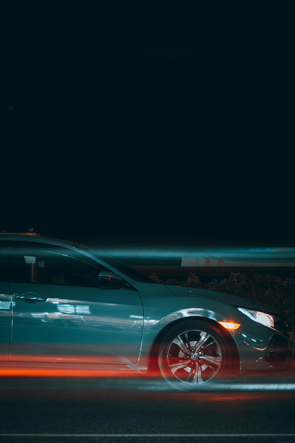 夜間の道路を走る赤い車