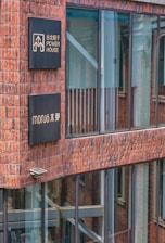 Installation of acrylic and stainless steel signage on a shop facade.