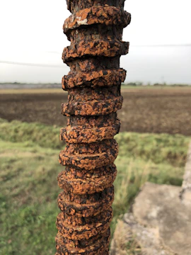 Close-up of rust-proof polymer rebar embedded in concrete at a coastal seawall construction site.