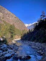 A peaceful mountain landscape in Asia with a winding river and clear blue sky.