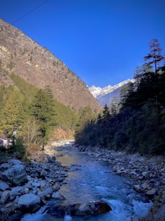 A peaceful mountain landscape in Asia with a winding river and clear blue sky.