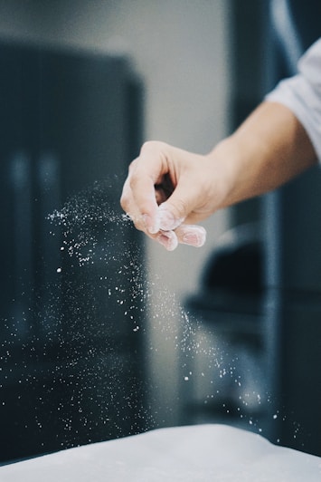 person holding water droplets on glass