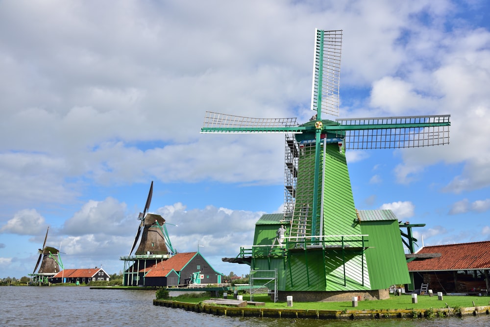 green and brown windmill near body of water during daytime