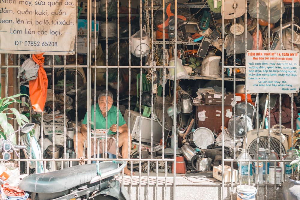 woman in green shirt standing in front of assorted cooking pots