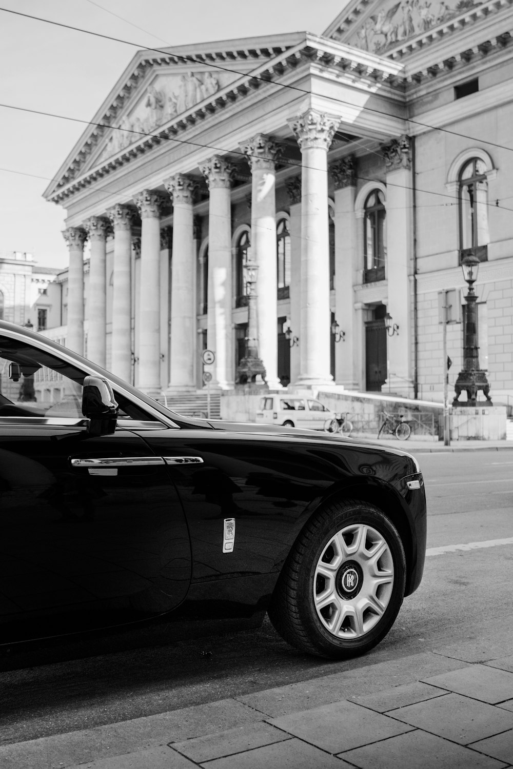 grayscale photo of car parked near building