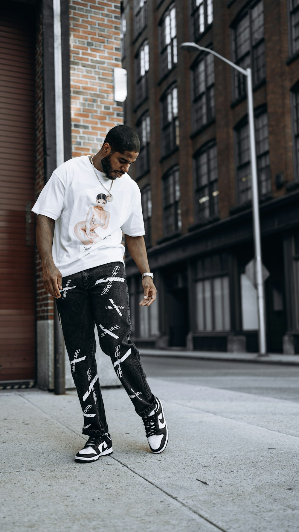 Man In White Crew Neck T-Shirt And Black And White Pants Standing On  Sidewalk During Photo – Free Providence Image On Unsplash