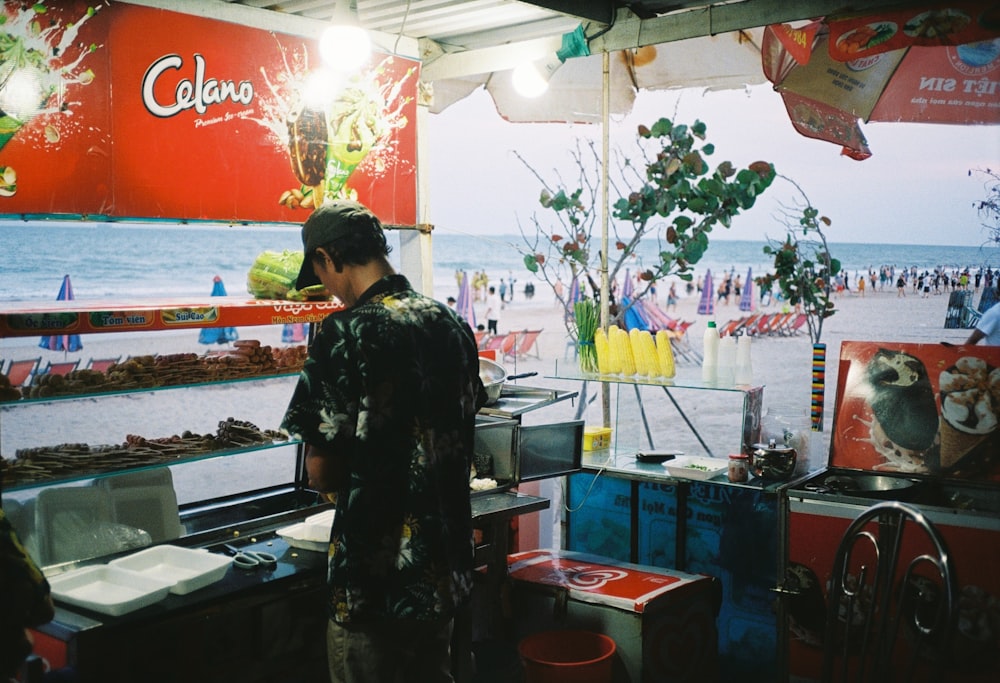 woman in black and white floral dress standing in front of food stand